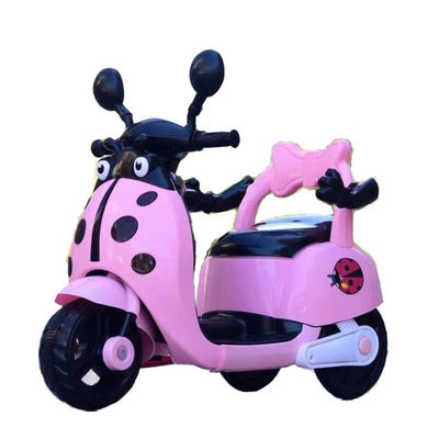 Muchos niños montan una motocicleta eléctrica de plástico con luces y música