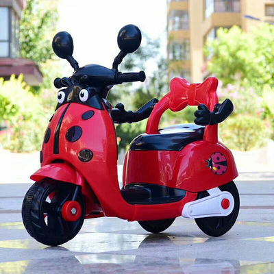 Muchos niños montan una motocicleta eléctrica de plástico con luces y música