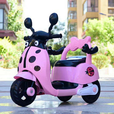 Muchos niños montan una motocicleta eléctrica de plástico con luces y música