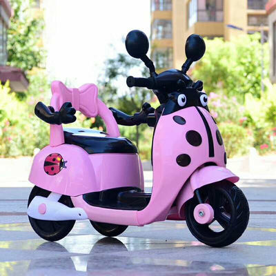 Muchos niños montan una motocicleta eléctrica de plástico con luces y música