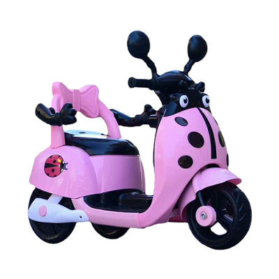 Muchos niños montan una motocicleta eléctrica de plástico con luces y música